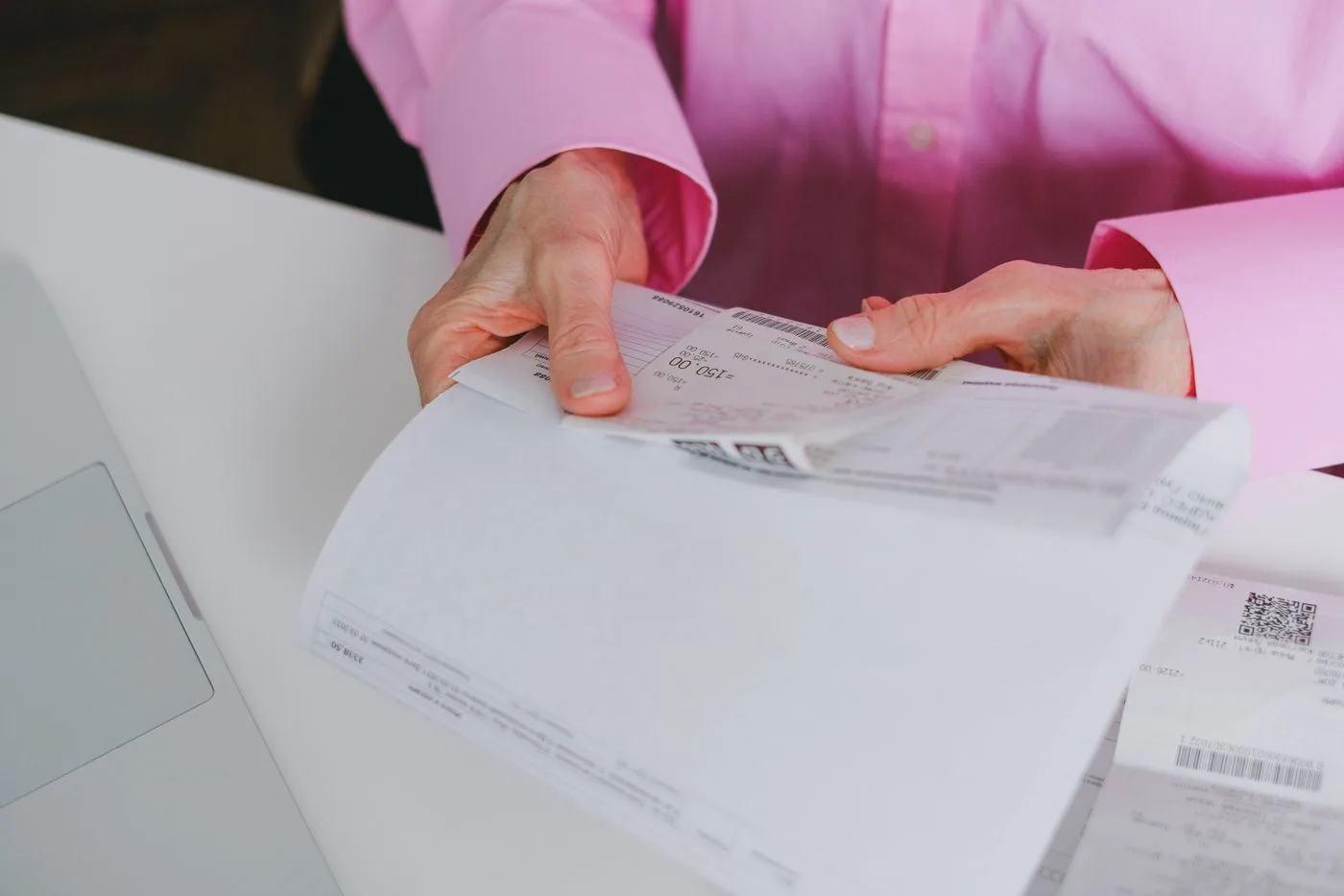 Business person handling paper receipts, meticulously organized