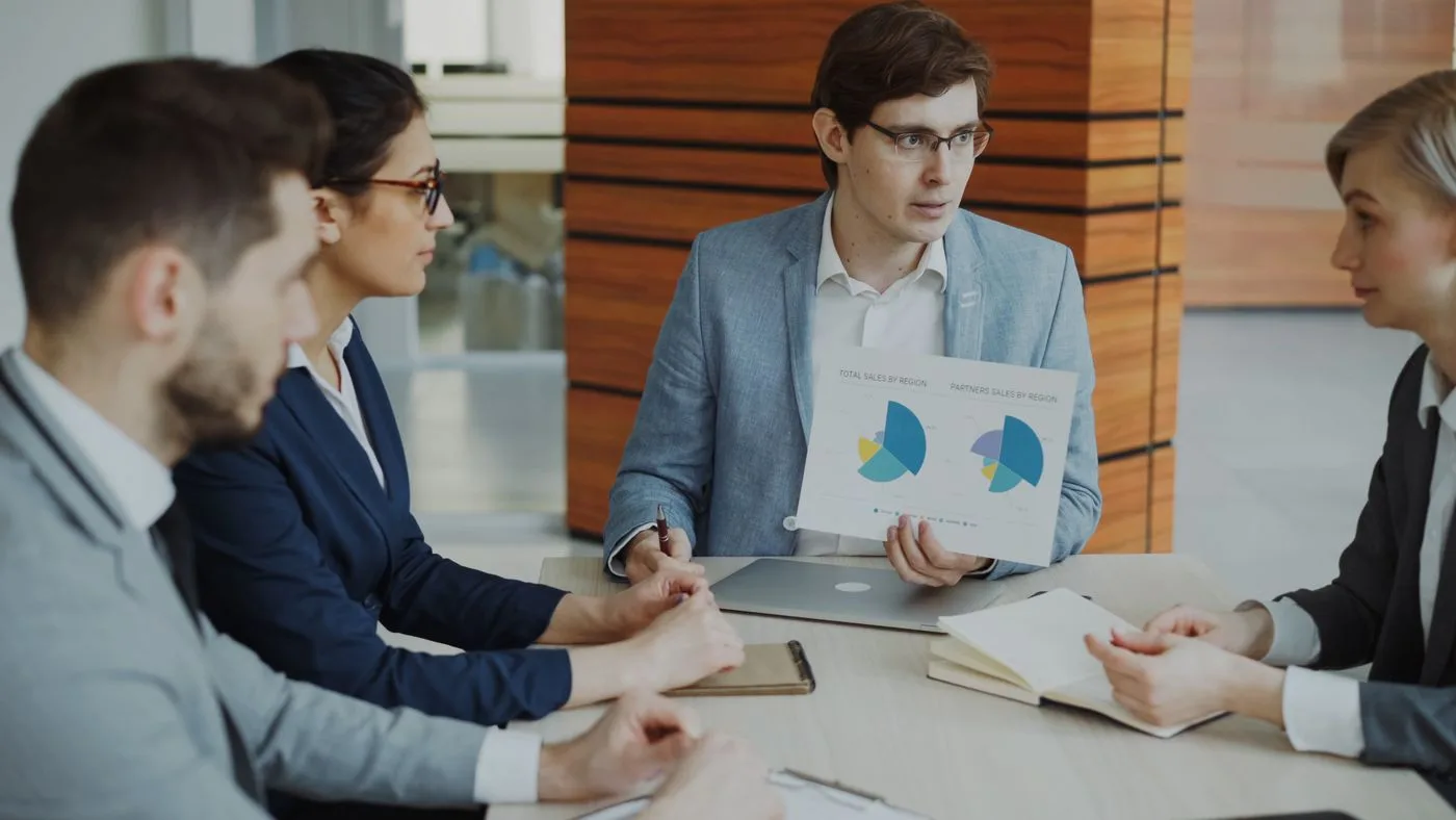 Group of professionals discussing charts during a business meeting