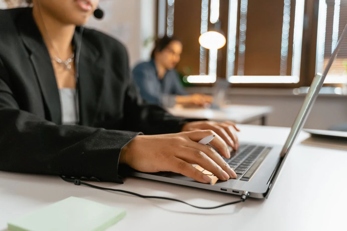 Call center agents working on laptops in a modern office setup