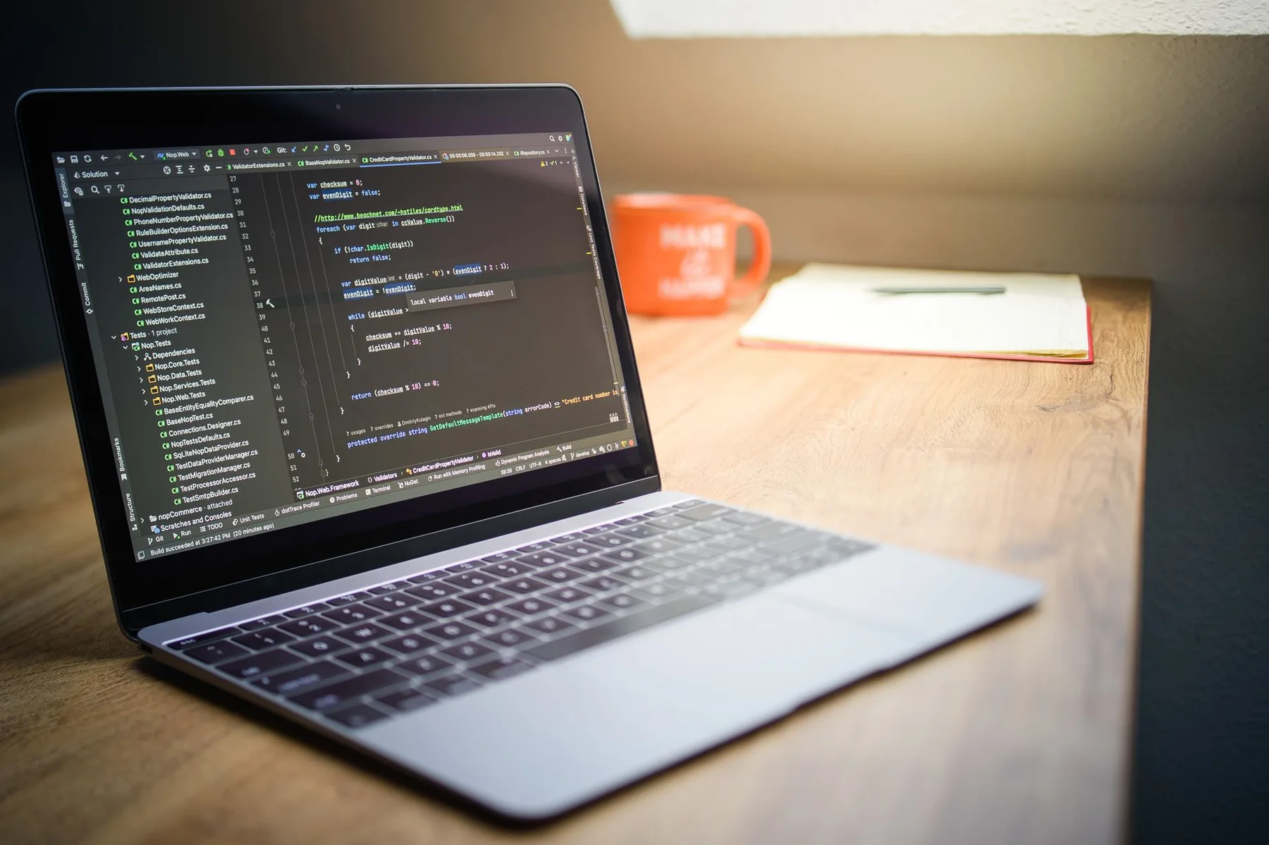 Developer workspace with a laptop showing source code, illustrating the build-versus-buy choice for custom AI marketing tools.