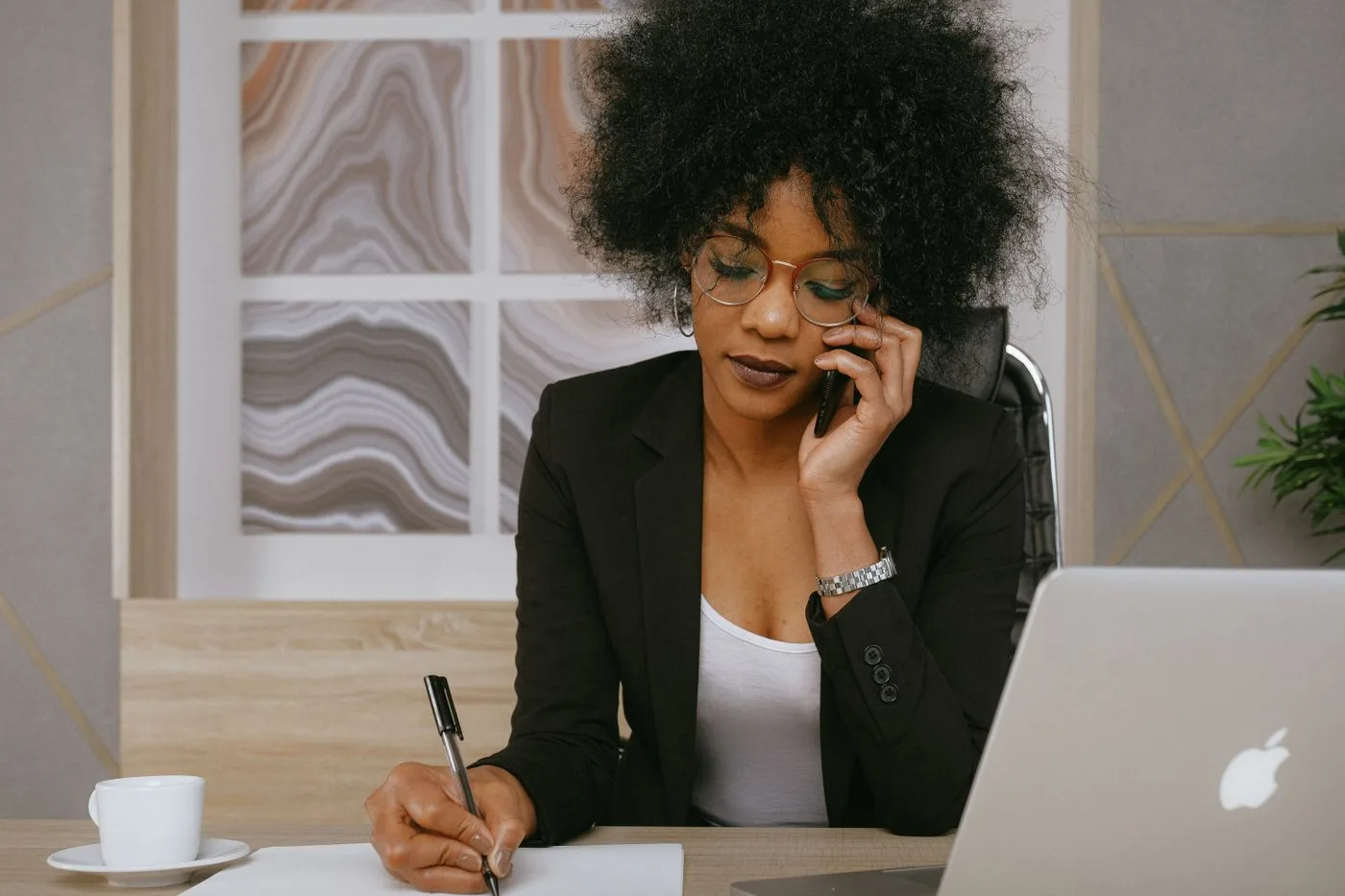 Businesswoman making a phone call while working at the desk, focused and professional