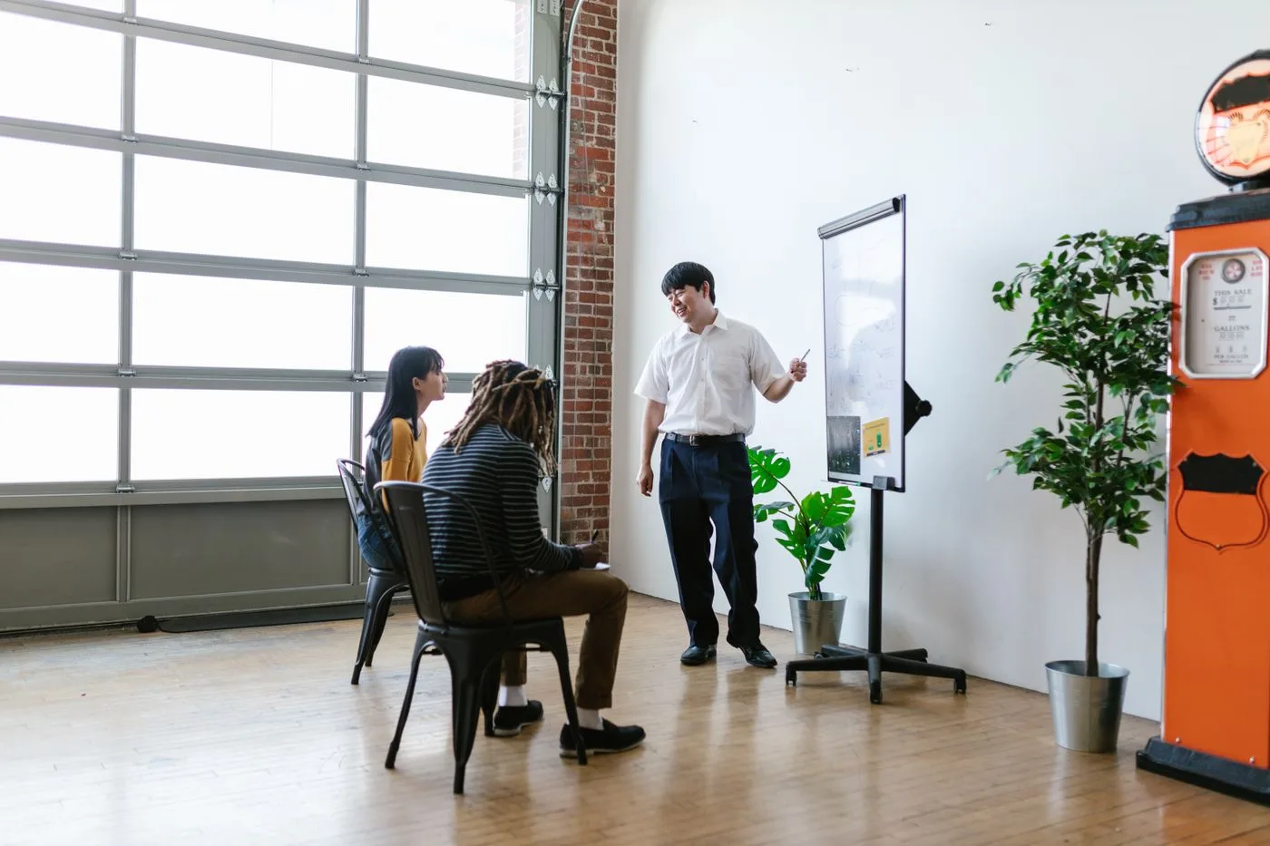 A meeting in a modern office with a presenter explaining concepts on a whiteboard