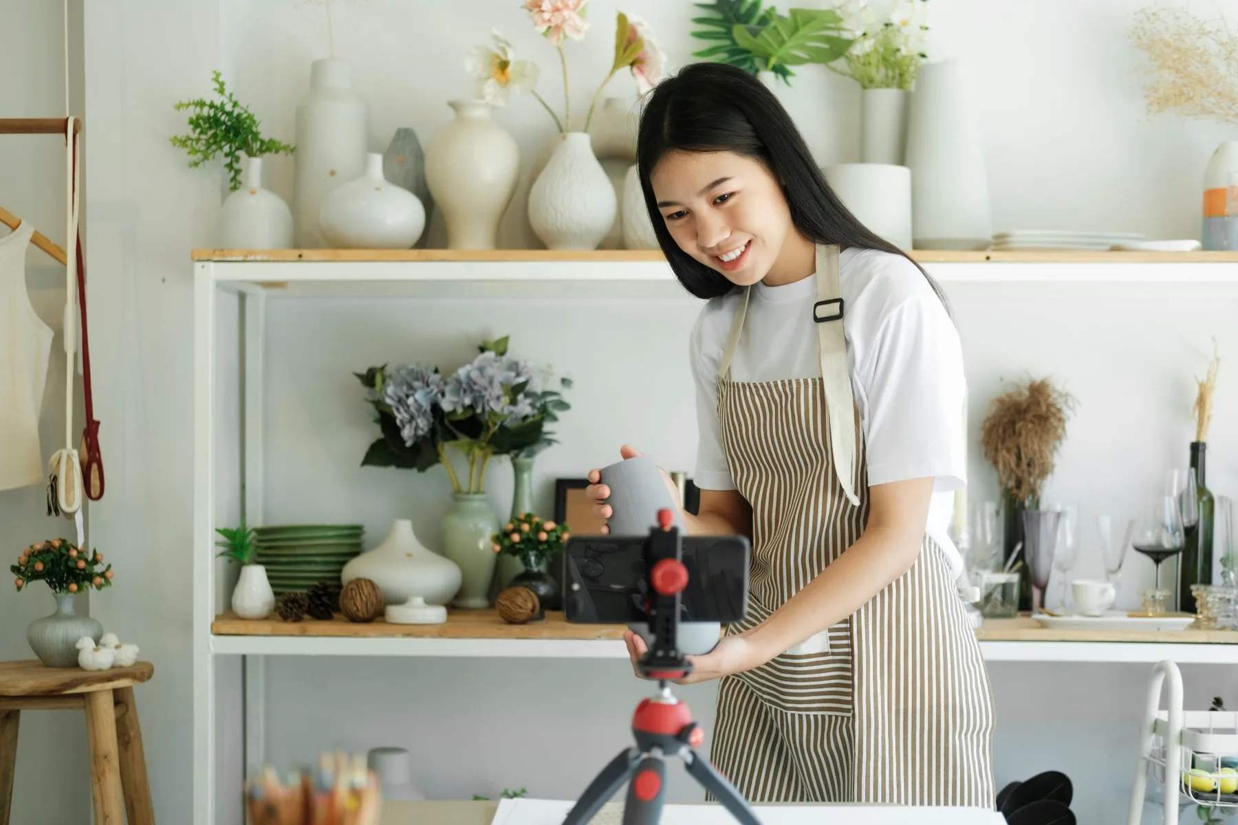 Small business owner recording a Reel about her ceramics on a phone mounted on a tripod