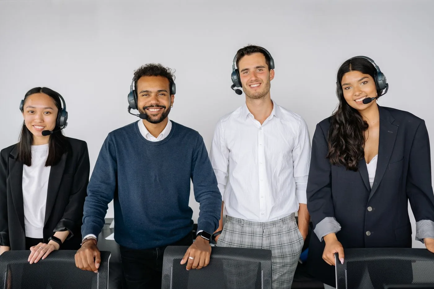 A diverse group of customer service representatives wearing headsets in a modern office