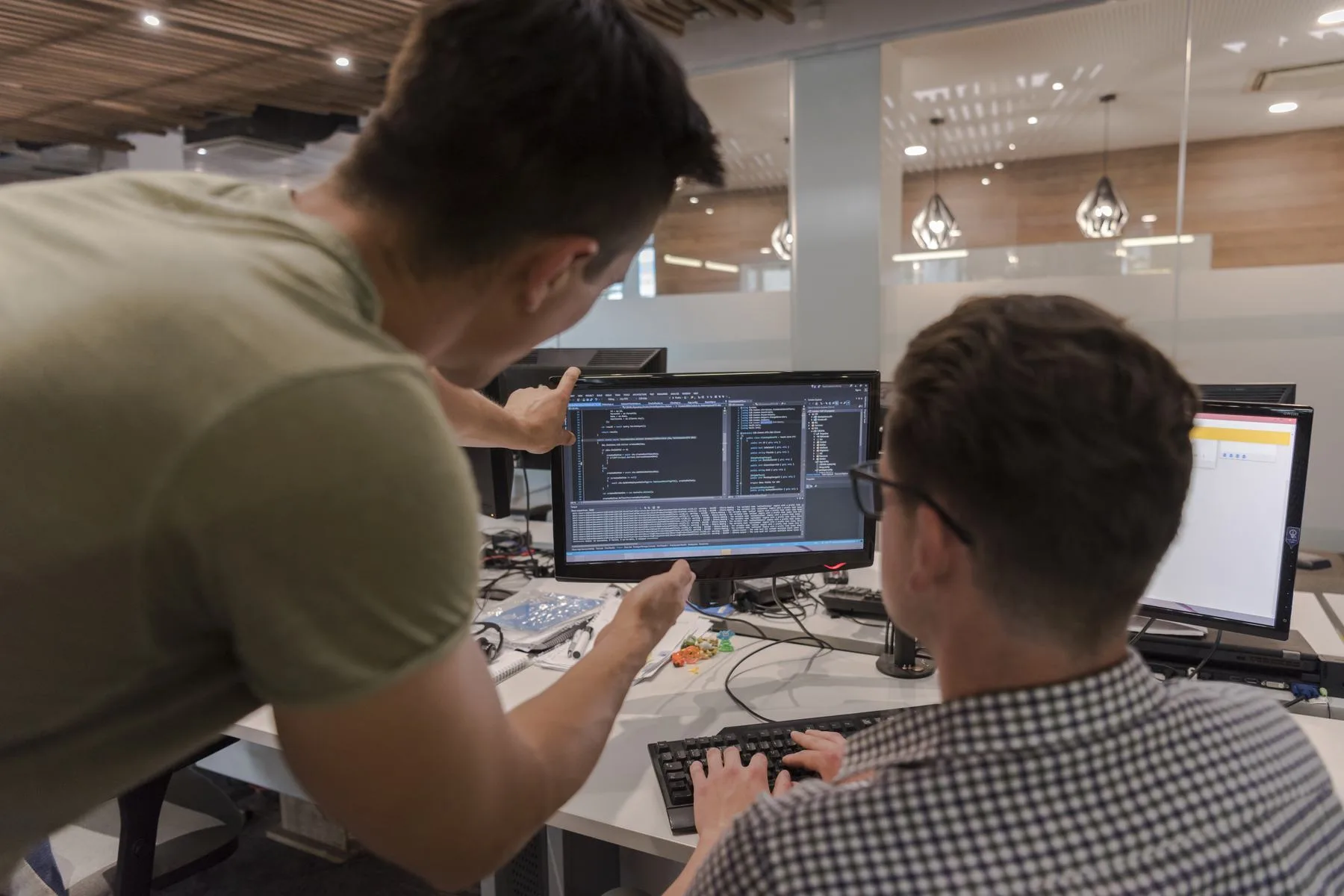 Two men reviewing code at a computer