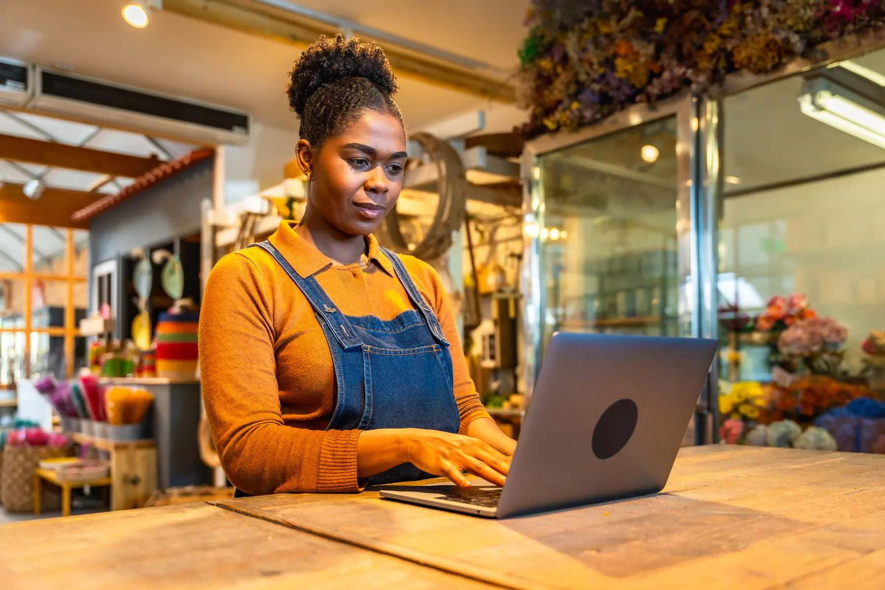 Woman working on laptop in her flower shop