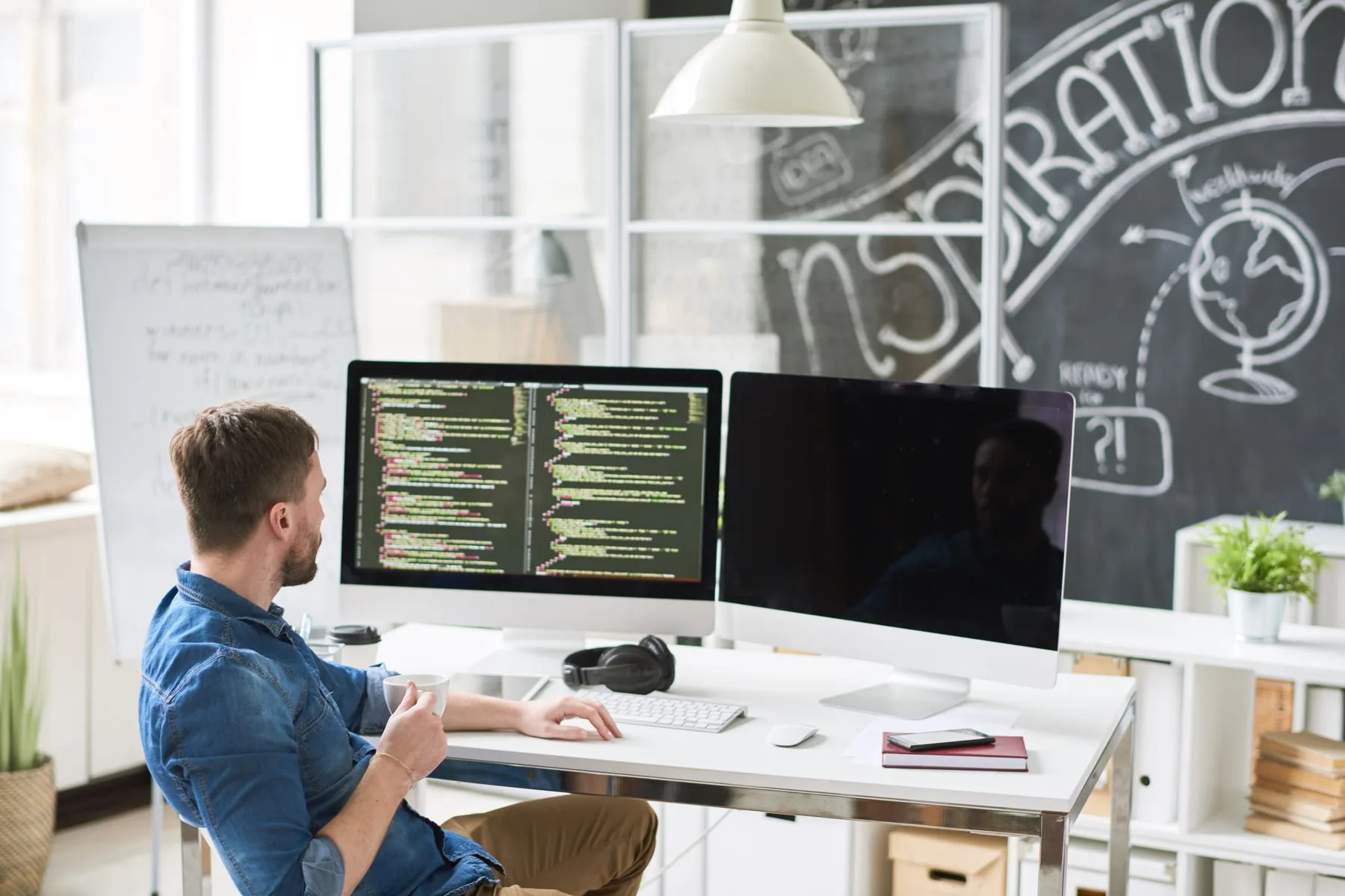 Adult man working with dual computer monitors