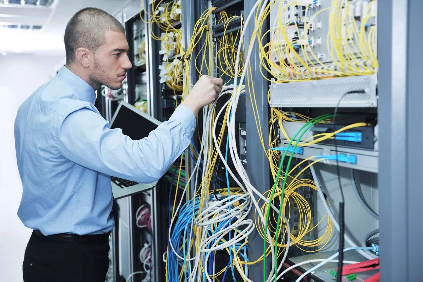 Man working on cables in server room