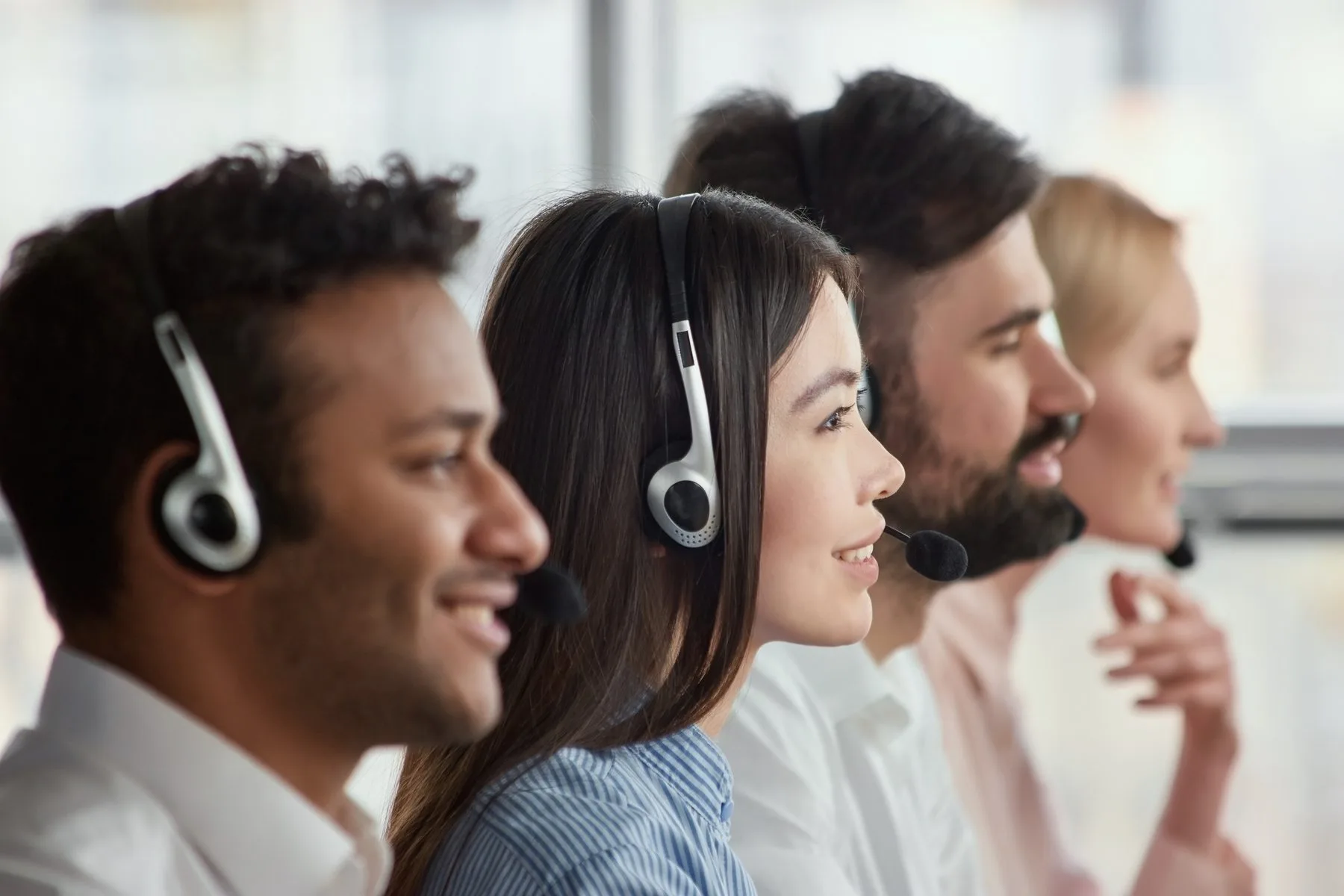 Smiling call center staff wearing headsets at work