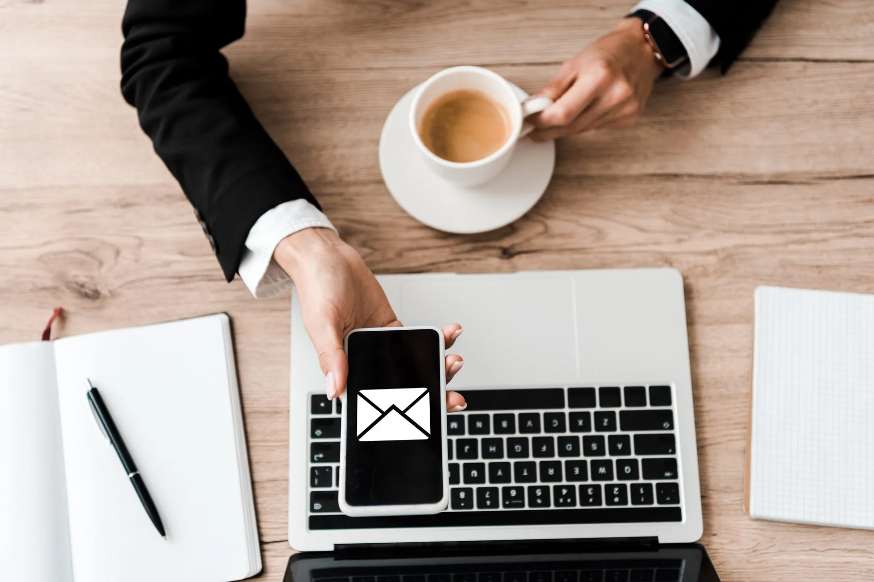 Email concept on phone with laptop and coffee