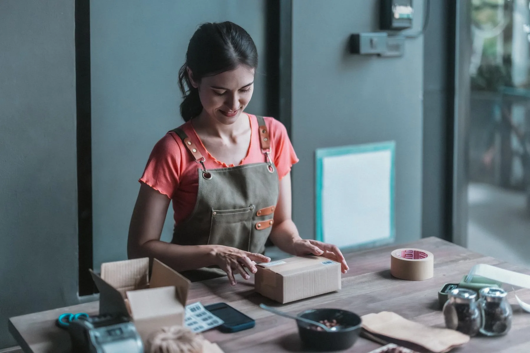 Young woman prepares orders in her store