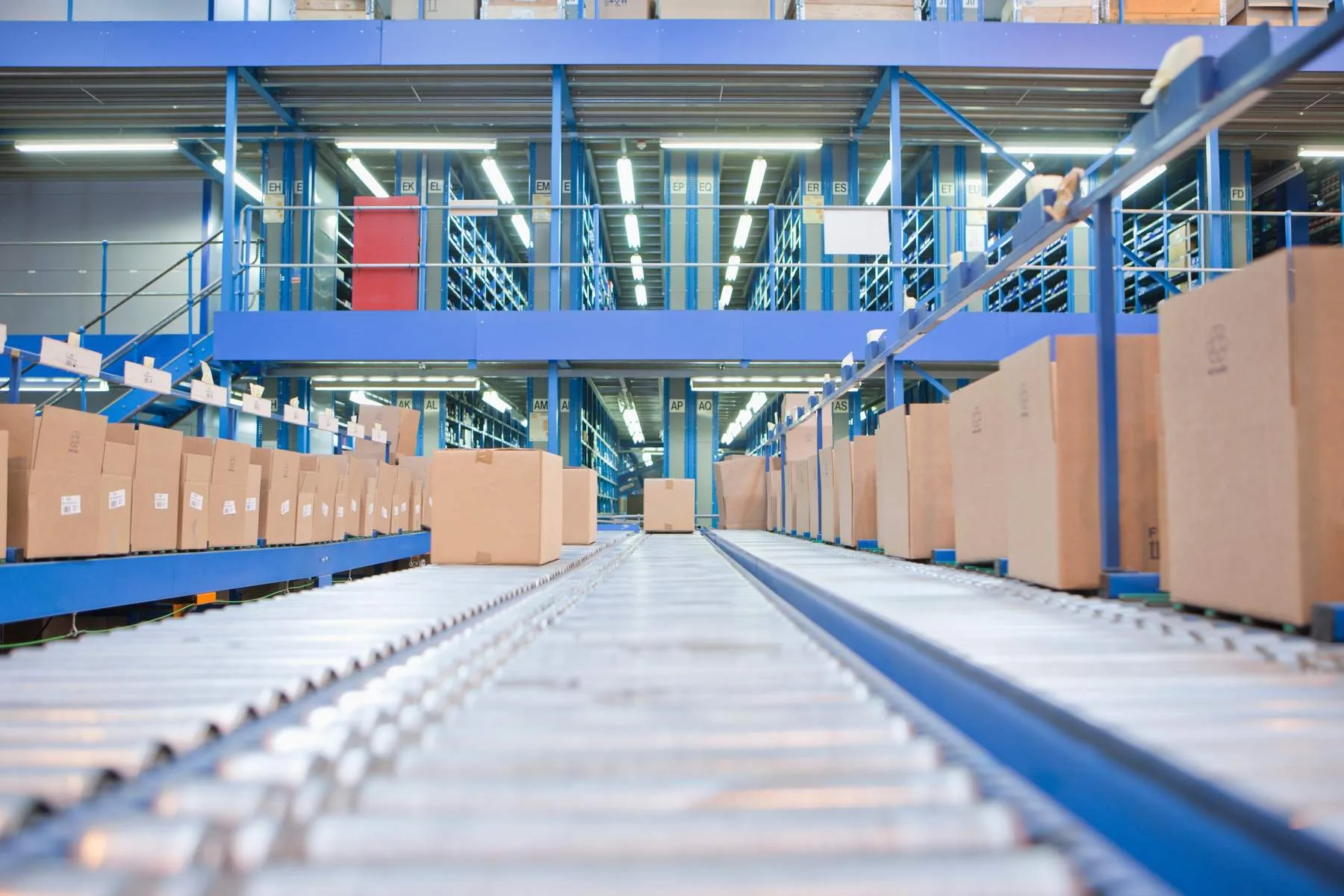 Cardboard boxes on conveyor belt system in warehou