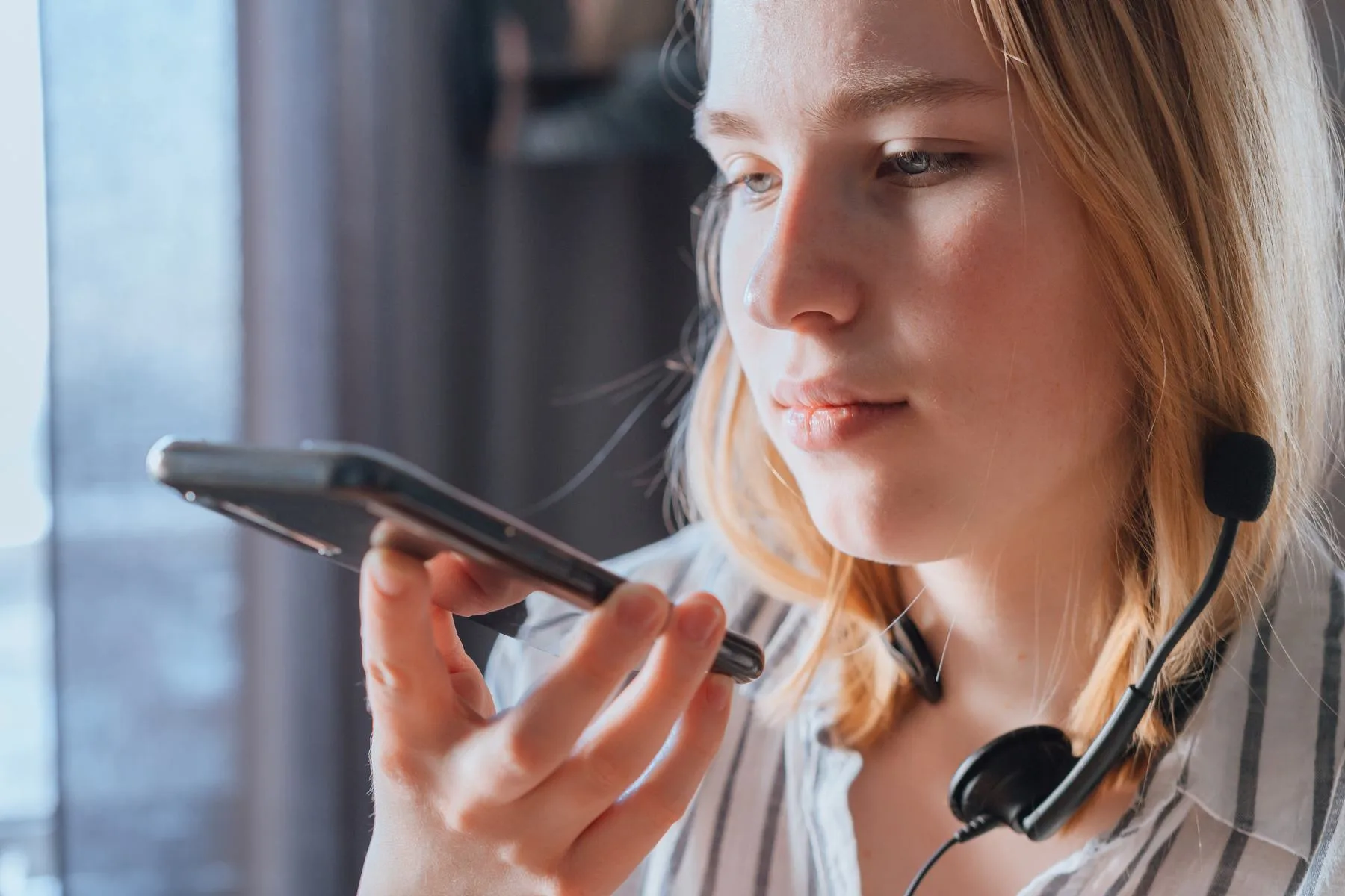 Young woman using a phone with a headset