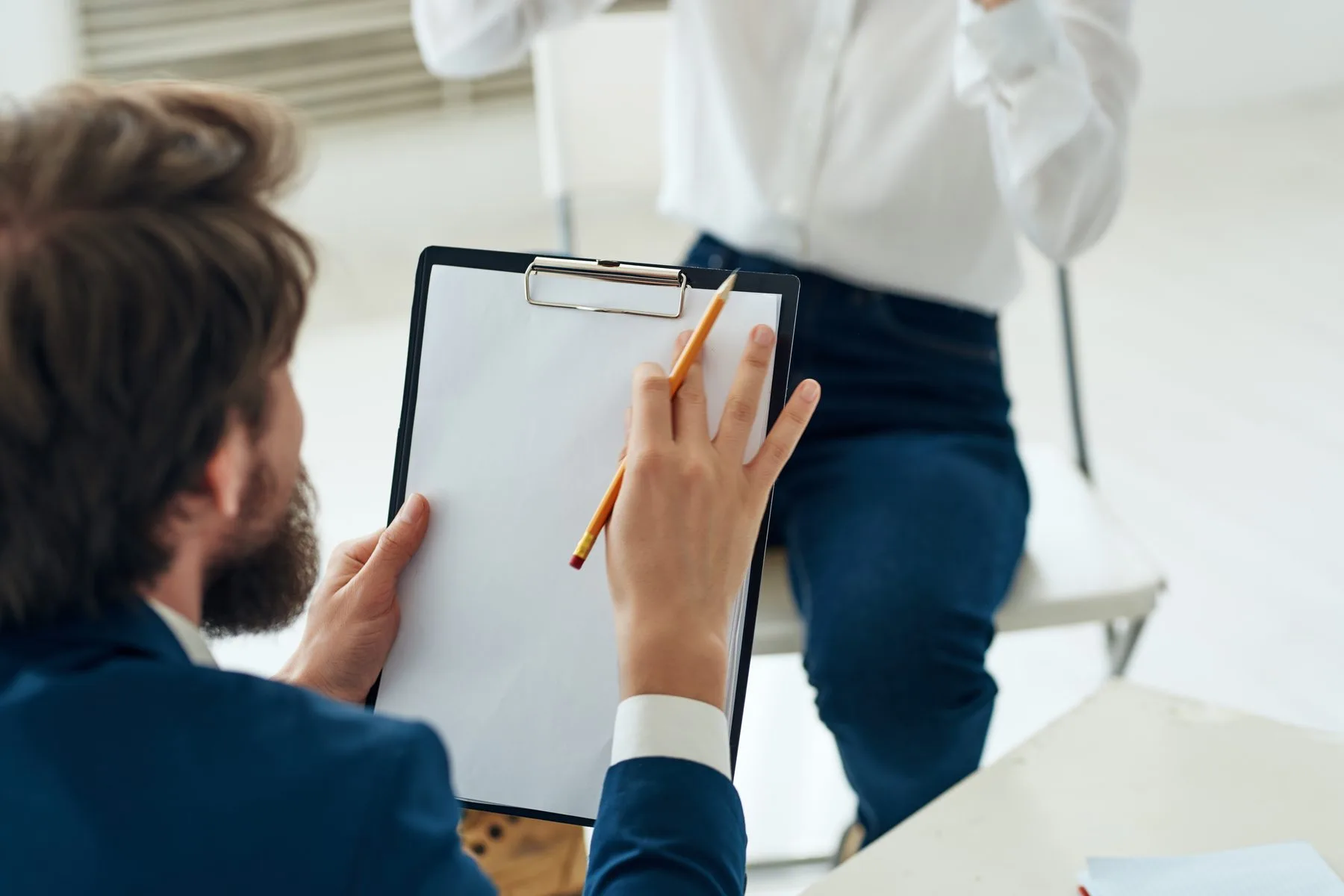 Adults in white room with note pad