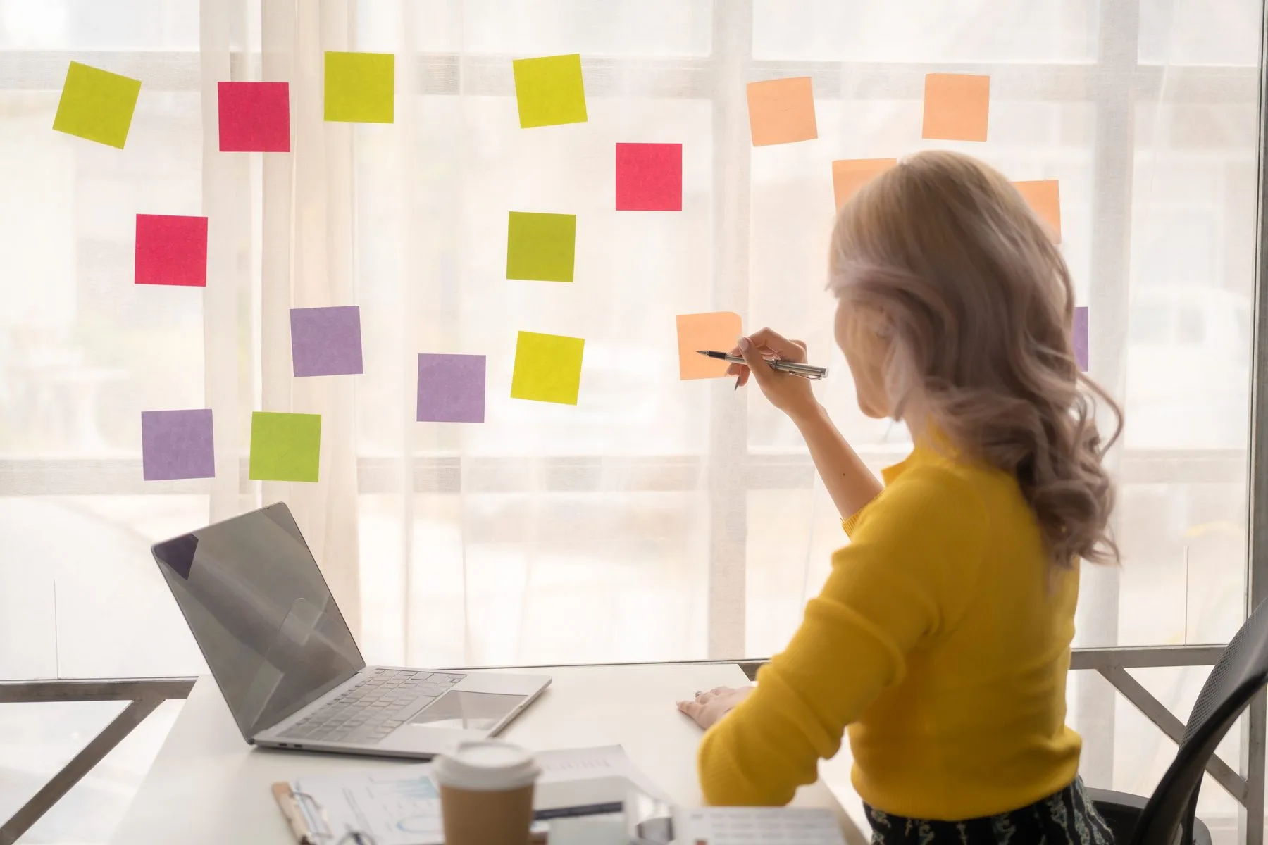 Woman working at desk planning with sticky notes