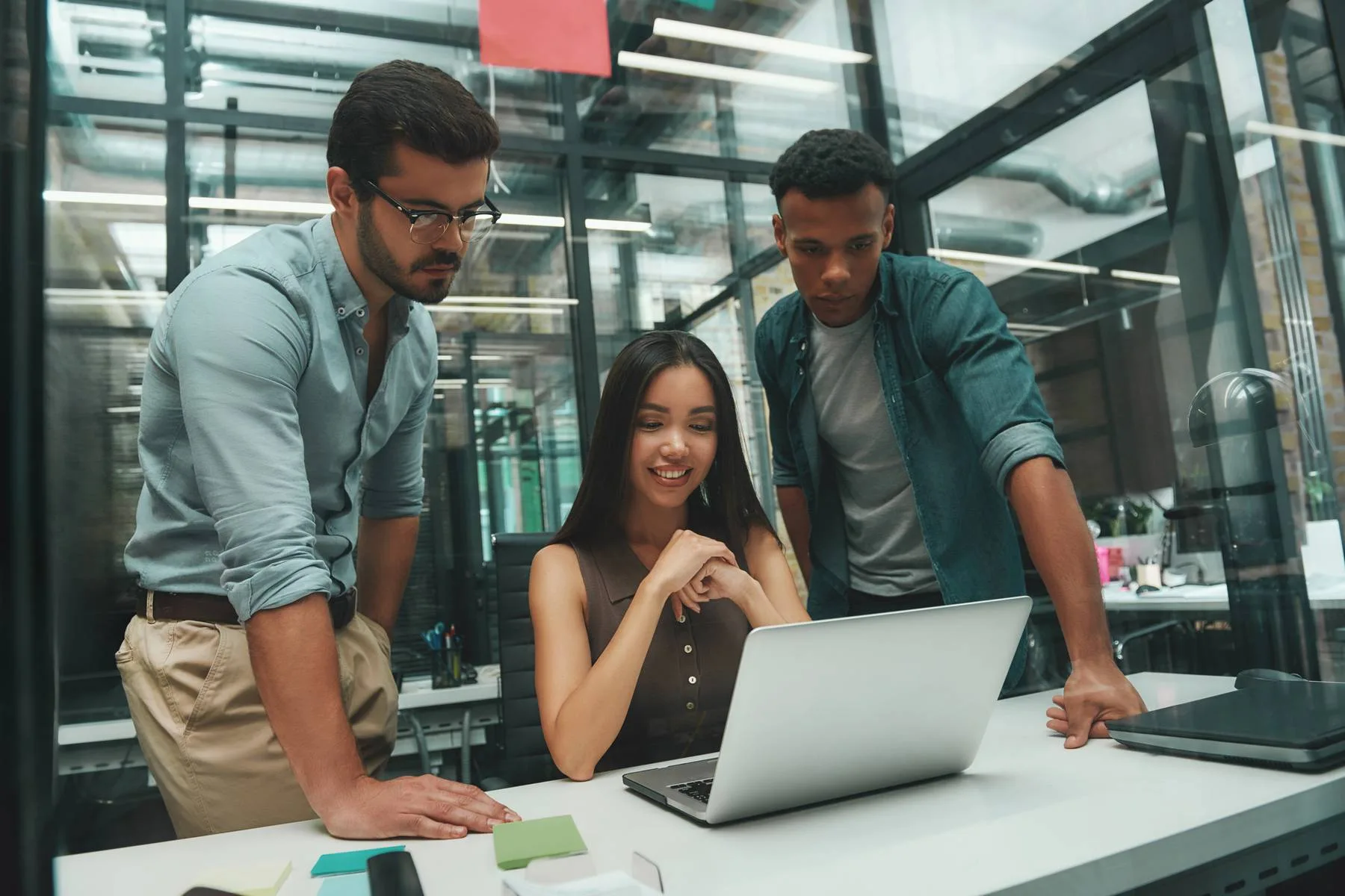 Team discussing project on laptop in modern office
