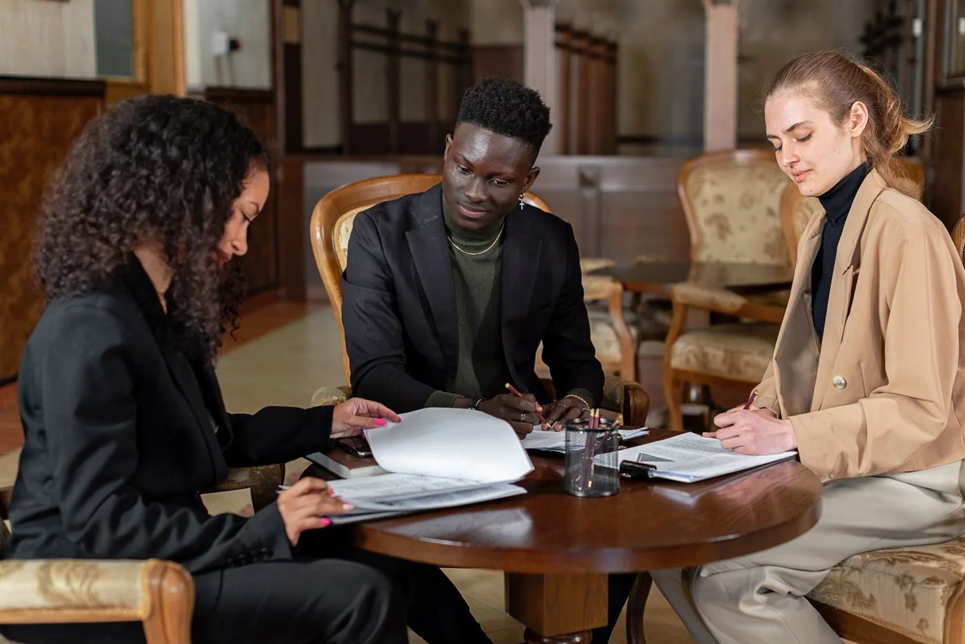 Three business colleagues collaborating and reviewing documents indoors