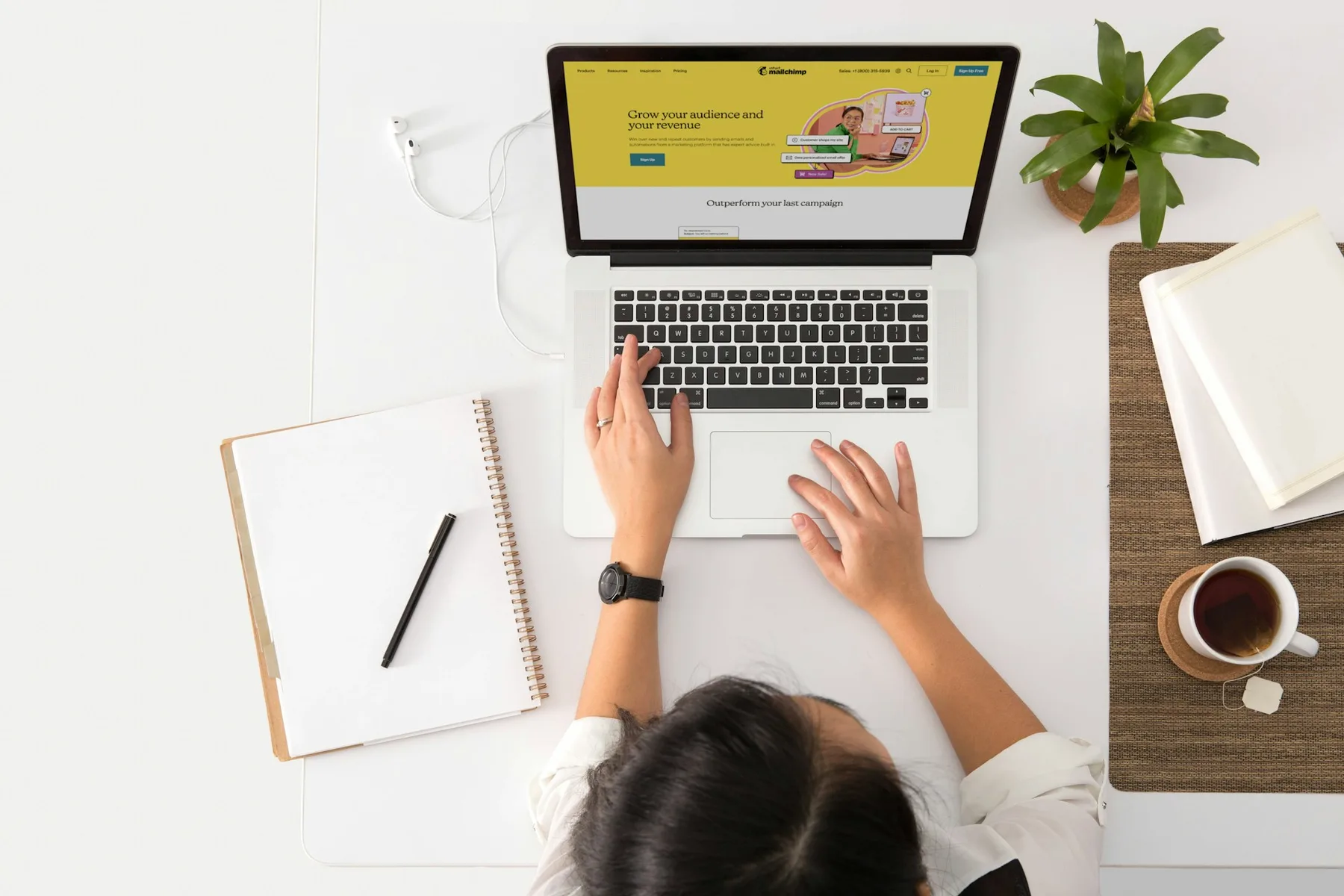 Marketer working at a clean desk on a laptop with a website and campaign open, illustrating online marketing in 2026.