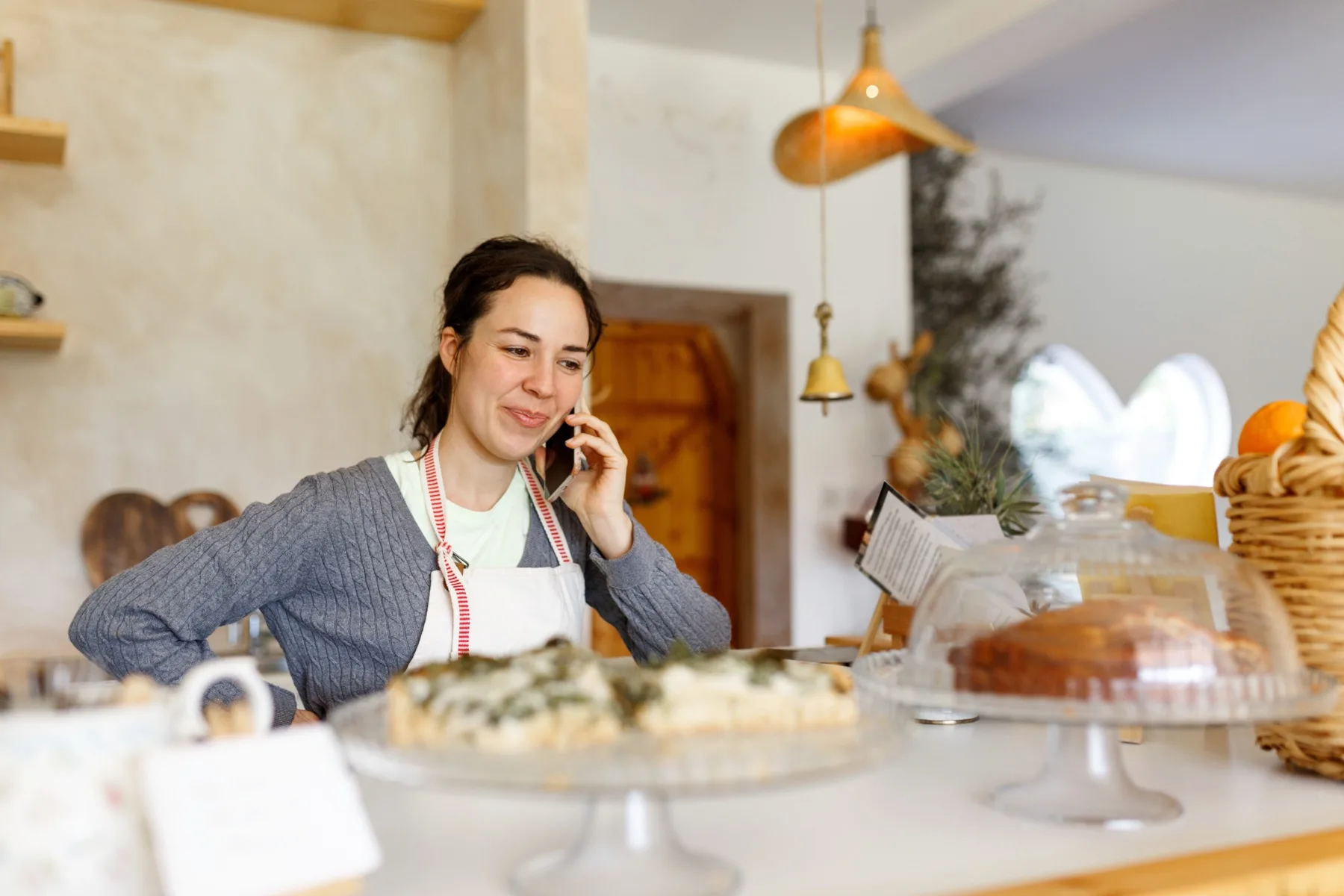 Bakery owner taking a phone call behind the counter